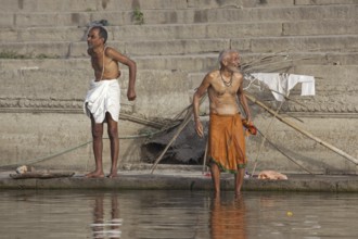 Indian men washing at a ghat along the holy Ganges river, Varanasi, Uttar Pradesh, India, Asia