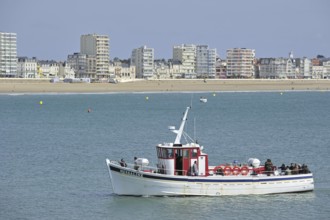 Fishing boat with sea anglers and apartments at Les Sables-d'Olonne, La Vendée, Pays de la Loire,