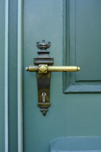 Old historical door handle on a green door