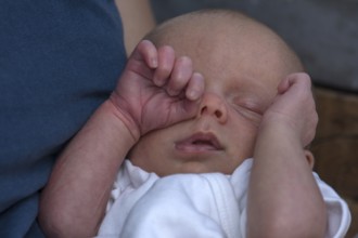 Infant rubbing his eye with his hand, Mecklenburg-Vorpommern, Germany, Europe