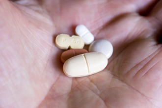 Hand holds various tablets, medicines