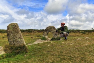 Mên-an-Tol, Men an Tol, cyclist beside perforated stone in a field, Bronze Age megalith, Penzance,