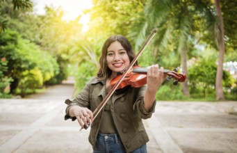 Young woman playing the violin outdoors. Portrait of a girl playing the violin outdoors, Close up