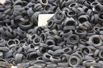 Old car tyres lie on stockpiles for recycling