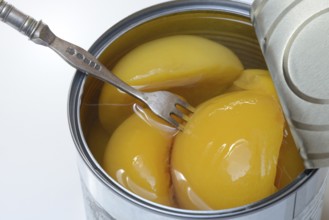 Peach, preserved peach halves with syrup in a tin can