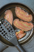 Artificial bacon as imitation meat, imitation bacon in pan, meat substitute