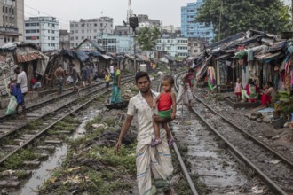 Father with his son walking on the railway tracks, Tejgaon Slum Area, Dhaka, Bangladesh, Asia