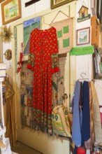 Red dress, ties and paintings for sale inside second hand goods and chattels store, Quebec, Canada,