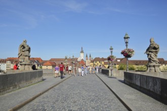 Pedestrians on the Old Main Bridge with sculptures and view of the old town, old, historic