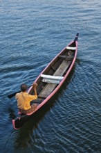 KERALA, INDIA, MAY 5, 2010: Indian man in small canoe boat in backwaters. Kerala backwaters are