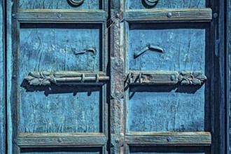 Latch with padlock on old textured door in India