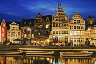 Old houses on Graslei street, canal and tourist boatds in the evening. Ghent, Belgium, Europe