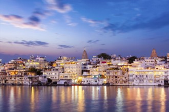 Evening view of illuminated houses on lake Pichola in twilight, Udaipur, Rajasthan, India, Asia