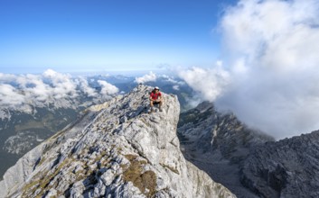 Mountaineer on a rocky narrow mountain path with mountain panorama, mountain tour to the summit of