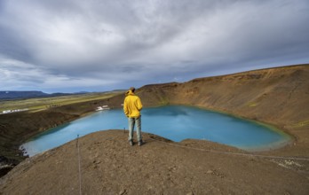 Tourist at volcanic crater with blue lake, volcanic lake, crater lake Viti at central volcano