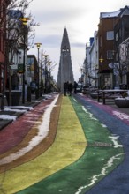 Shopping street Skolavördustigur, painted in the colours of the rainbow, lightly covered with snow,