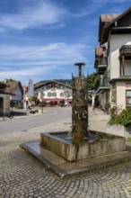 Bronze fountain with various Oberammergau themes in the centre of Oberammergau, district of