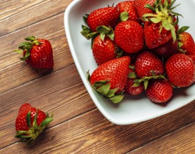 Strawberries (Fragaria) on wooden table