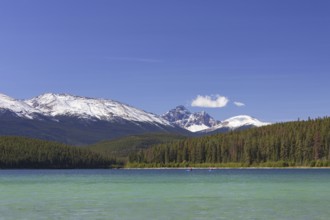 Two kayakers kayaking on Pyramid Lake at the foot of Pyramid Mountain in the Jasper National Park,