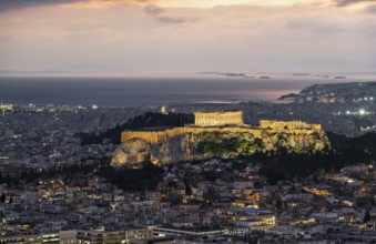 View over the sea of houses of Athens, illuminated Parthenon temple on the Acropolis, from Mount