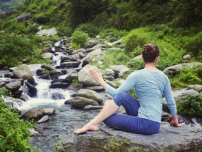 Yoga exercise outdoors, woman doing Ardha matsyendrasana asana, half spinal twist pose at tropical