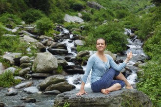 Yoga exercise outdoors, woman doing Ardha matsyendrasana asana, half spinal twist pose at tropical