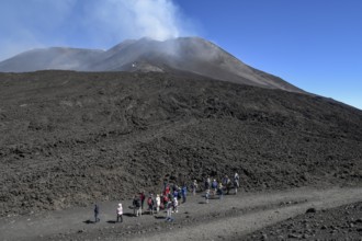 Hikers in the crater landscape of the volcano Etna, summit region, province of Catania, Sicily,