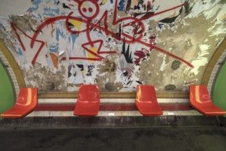 Red seats in the metro in front of a torn down billboard, Paris, France, run down, graffiti, Europe