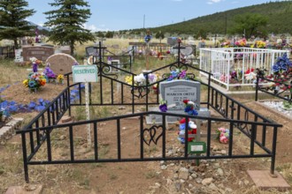 Cerro, New Mexico, A rural cemetery where graves are decorated with flowers and flags. One burial