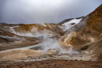 Bridge and steaming streams between colourful rhyolite mountains and snowfields, Hveradalir