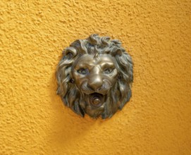 Doorbell knob in the shape of a lion on a yellow house wall, Burano Island, Venice, Veneto, Italy,