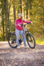 Woman on Ebike through autumn forest, Black Forest, Gechingen, Germany, Europe