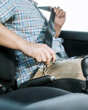 Driver hands fastening the seat belt, Close up of person hands putting on the seat belt. Driver's