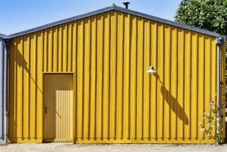 Wooden façade of a yellow beach hut with door and lamp, Île d'Oléron, Oleron Island, Charente