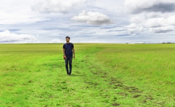 Traveler man walking in the beautiful countryside. Backpacker man walking in a countryside.