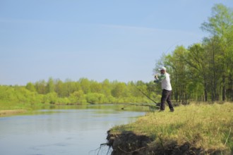 Fisherman throwing the bait with a spinning rod. Outdoor weekend activity. Photo with shallow depth