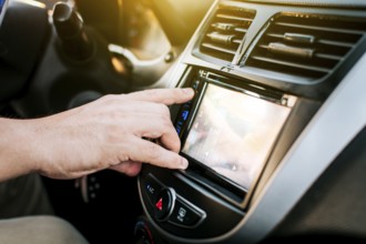 Driver hands changing the radio station. Close up of hands changing the car radio station. Concept