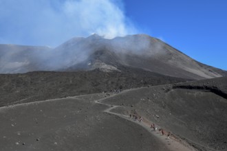 Hikers in the crater landscape of the volcano Etna, summit region, province of Catania, Sicily,