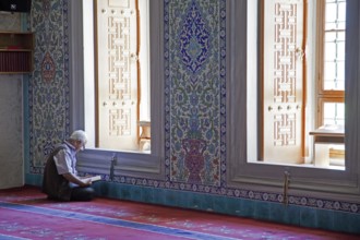 Turkish man reading the Koran in the Kocatepe Camii, largest mosque in Ankara, Turkey, Asia