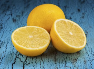 Lemon and cut half slice on blue wooden background