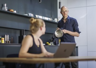 Symbolic photo on the subject of division of labour for couples in the household. A woman sits at a