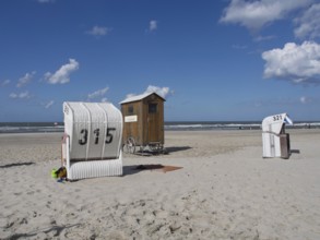 Beach chairs and a wooden hut stand side by side on the quiet beach, spiekeroog, east frisia, north