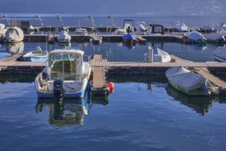 Jetties with motorboats, marina, lake, haze, reflections on the water surface, Lake Lugano, Lugano,