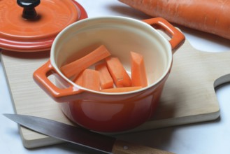 Carrot, carrot sticks in pot and kitchen knife