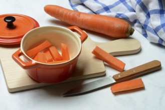 Carrot, carrot sticks in pot and kitchen knife