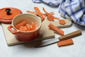 Carrot, carrot sticks in pot and kitchen knife