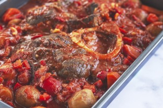 Ossobuco stew with vegetables, knuckle on the bone with new potatoes, in tomato sauce, homemade,