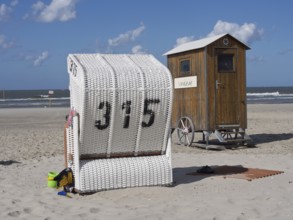 White beach chair and wooden hut on the beach under a blue sky, spiekeroog, east frisia, north sea,