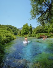 Muzina, Albania, tourists bathe in the Syri i Kaltër, THE BLUE EYE, is the country's most