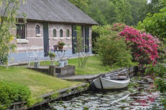 Cosy house on the canal with boat and flowering shrubs in an idyllic area, Giethoorn, municipality